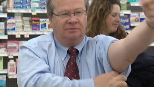 NB Health Minister prepares to receive a flu shot at a pharmacy to promote the service. Photo source: cbc.ca