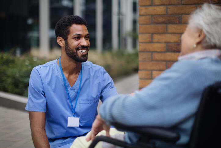 A Personal Support Worker Certificate holder speaking gently with a resident