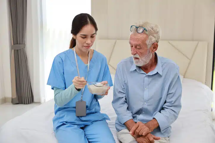 A personal Support Worker in Ontario assisting a senior patient with daily care