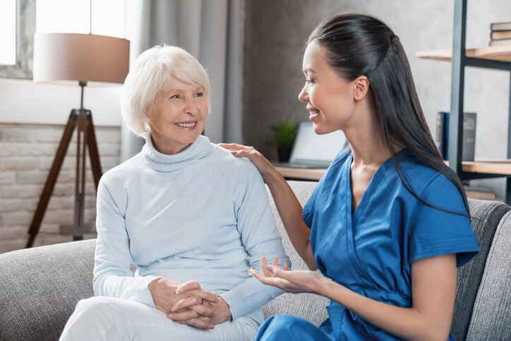 A compassionate Personal Support Worker Certificate graduate interacting with a senior client