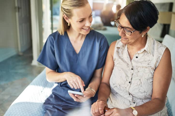 A friendly female PSW interacting with an elderly client in a home