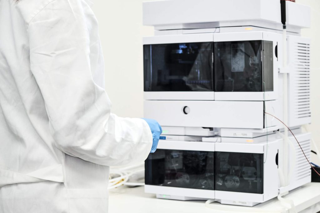 Laboratory technician operating chromatography equipment during food quality testing