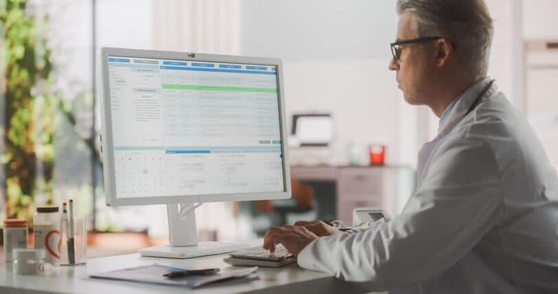 A clinical research certificate graduate reviewing trial data on a computer