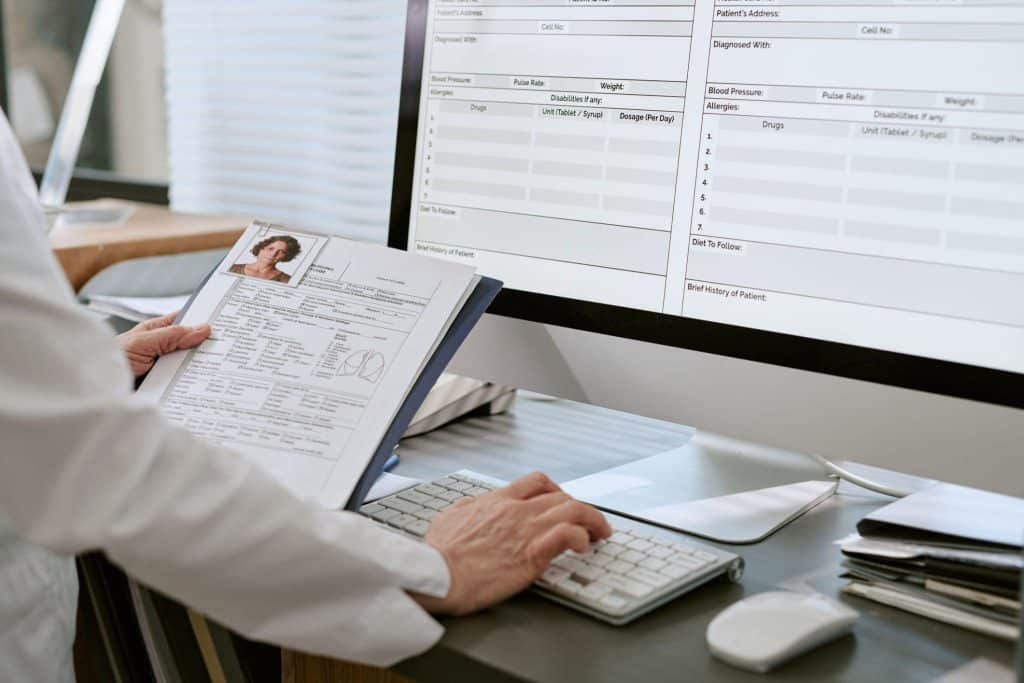 A clinical research monitor examining study records for clinical research compliance
