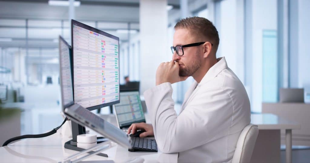 clinical research professional reviewing pharmacovigilance safety database for adverse event trends