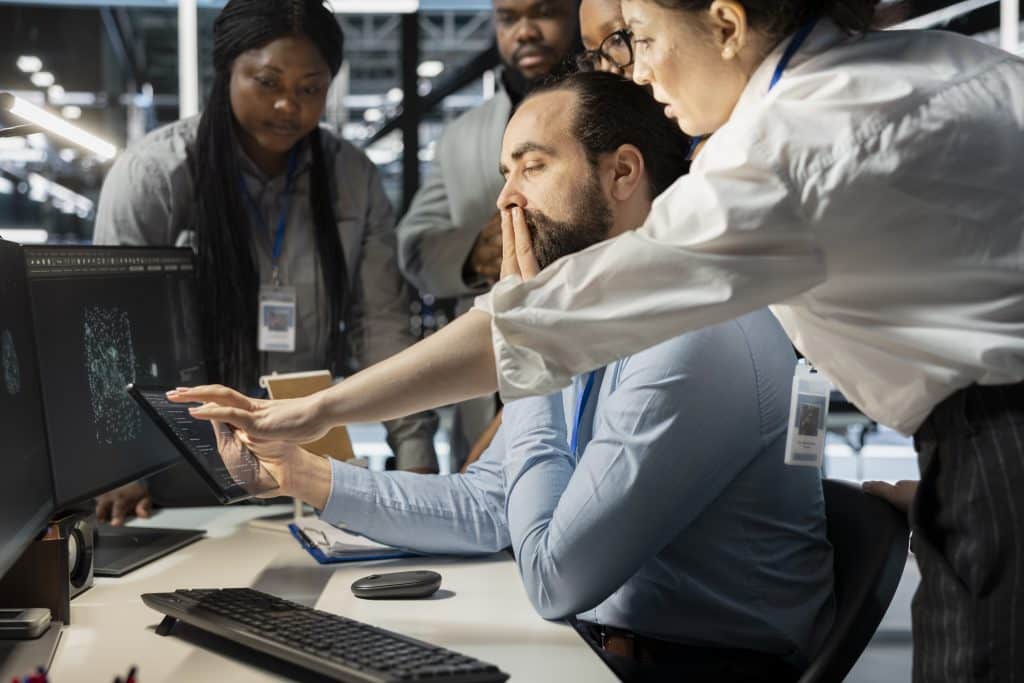 A Cybersecurity team discussing control assessment results in a server room
