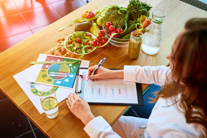 A Food and Nutrition Management Program graduate worker preparing a nutritious meal plan for a patient