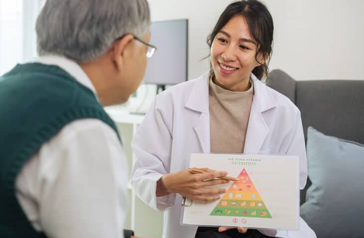 A food and nutrition training graduate reviewing a senior’s nutrition plan