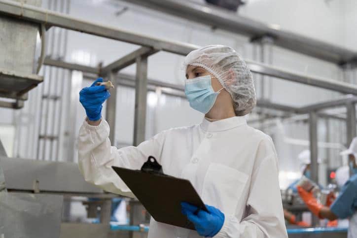A food manufacturing worker collecting an environmental monitoring sample