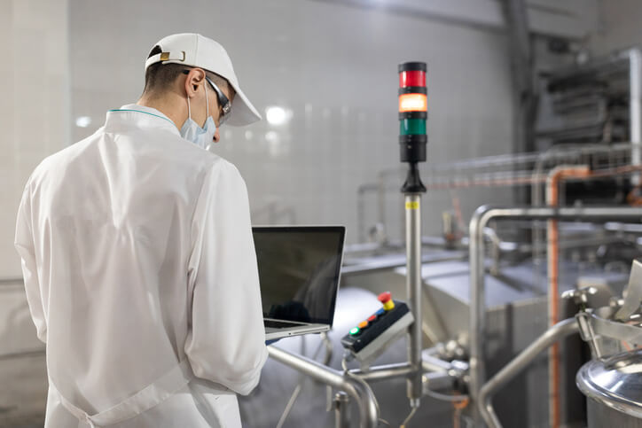 A technician monitoring critical control points on a food production line