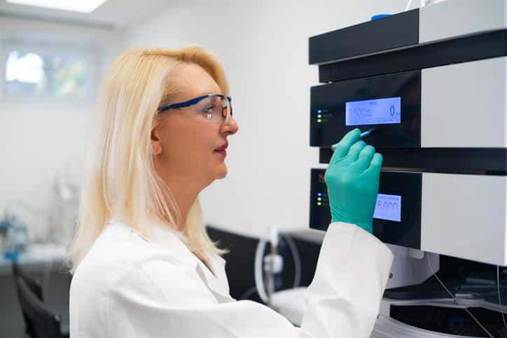 A researcher using HPLC during pharmaceutical research training