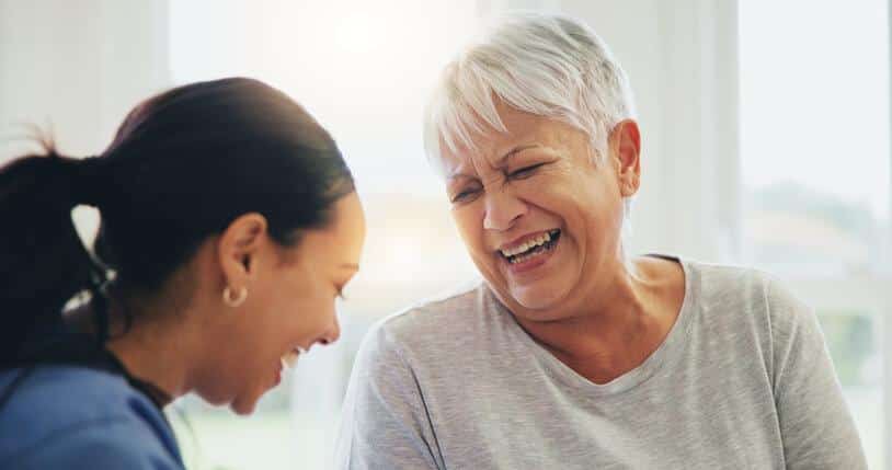 An elderly patient sharing a laugh with a personal care worker