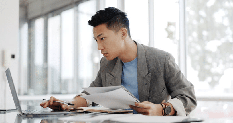 A regulatory affairs associate reviewing product approval documents in an office setting
