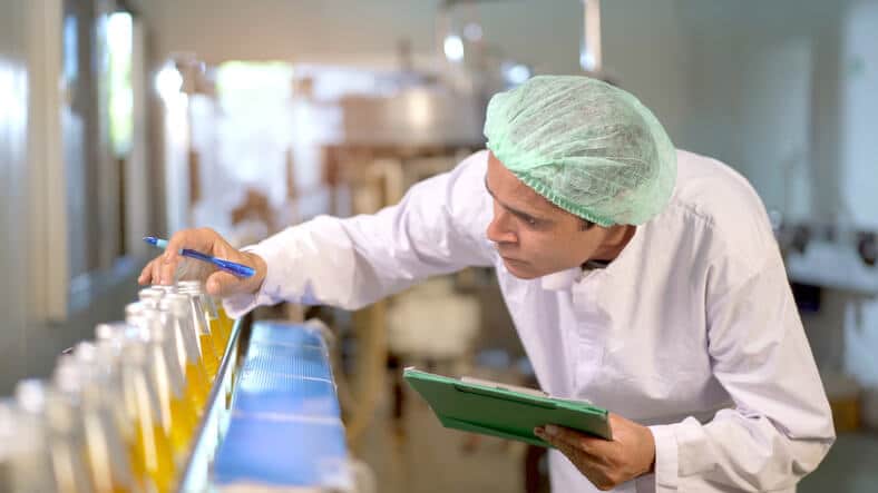 A quality assurance specialist reviewing pharmaceutical batch records before product release