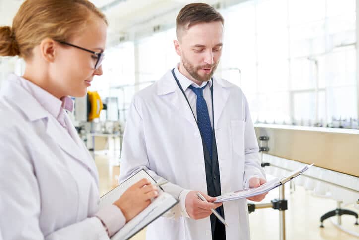 Pharmaceutical quality assurance and quality control professionals reviewing batch release documentation together before product approval