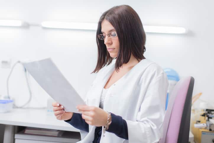A pharma QA student reviewing GMP documents in class