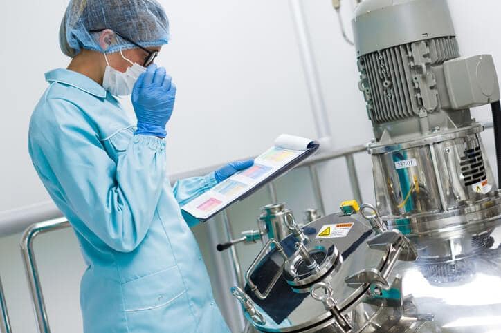 A technician performing process validation in a pharmaceutical laboratory.