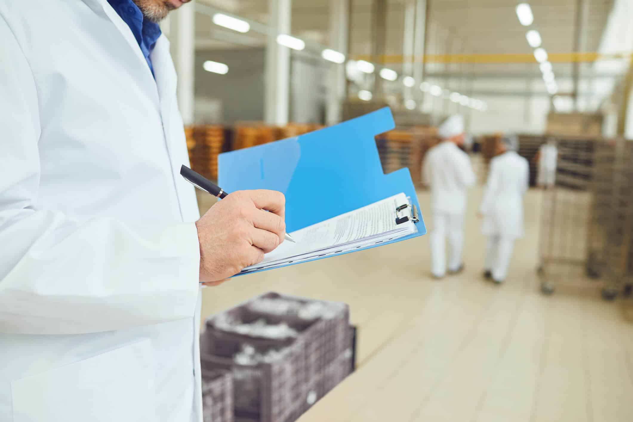A food safety professional reviewing traceability records in a manufacturing facility